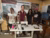 Four people standing behind a sewing machine in a workshop