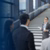 presenter speaking to colleagues near a staircase in an office setup
