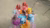 Women in colorful saris mixing Holi powders around a round table