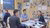 Three professionals conversing at a table in the IHS Pavilion booth