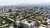 Aerial view of grid-patterned low-rise apartments with tree-lined streets and distant hills