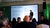 Speaker presenting slides to seated audience in conference room