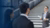 presenter speaking to colleagues near a staircase in an office setup
