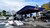 Severely damaged gas station with collapsed canopy and debris scattered across forecourt