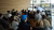 audience in wood-paneled space listening to IHS director