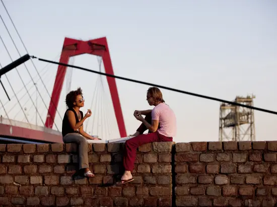 Two people sitting on a wall in Rotterdam 